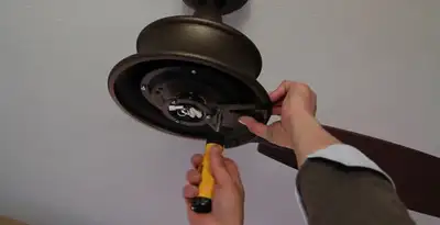 Electrician installing ceiling fan mounting bracket and fixture in Madison, WI