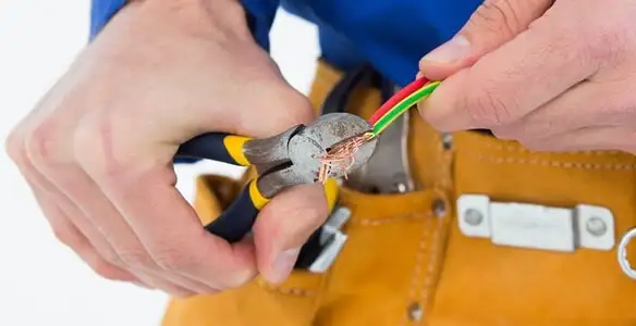licensed electrician securing electrical wiring with professional tools during service work in Madison, WI