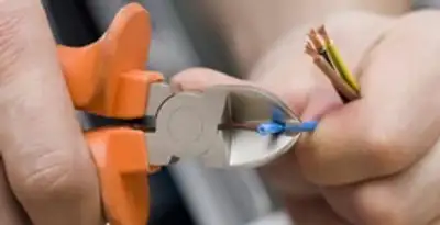 licensed electrician performing precise wire cutting and preparation during electrical service in Madison, WI