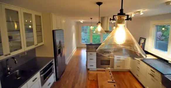 Residential electrician installing modern indoor light fixture in a home in Madison, WI