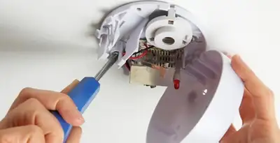 Certified technician wiring smoke detector during installation in Madison, WI